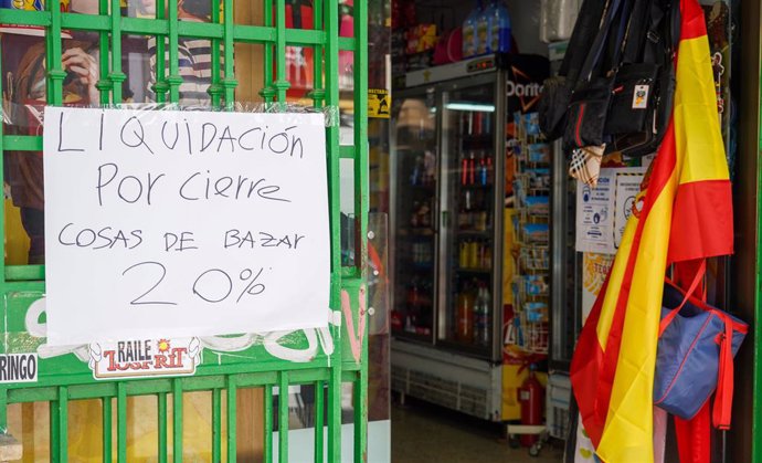 Archivo - Una tienda china con un cartel que pone el la puerta dos carteles que ponen "Liquidación por cierre"   en el primer día en el que la ciudad entra en la fase 3. Sevilla a 8 de junio del 2020