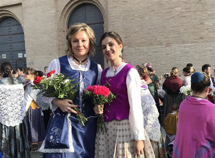 Oferentes llevan flores a la virgen del Pilar.