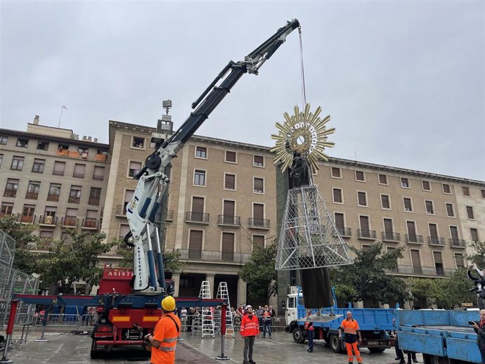 La colocación de la imagen de la Virgen del Pilar en lo alto de la estructura floral se ha realizado por parte de las Brigadas Municipales, con la ayuda de una grúa.