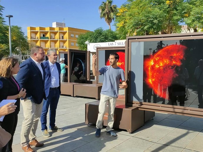El comisario de la exposición 'Otros Mundos' de Fundación La Caixa, Kike Herrero, explica al alcalde de Mérida, Antonio Rodríguez Osuna, una de las fotografías a gran tamaño expuestas en la plaza de Margarita Xirgu.