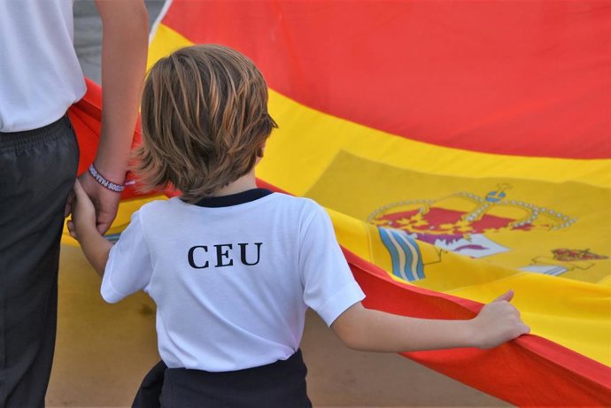 Un alumno de Infantil porta la bandera de España en el marco de las actividades de la Fiesta Nacional.