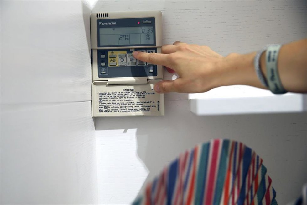 Archivo - Un trabajador pone la temperatura de su establecimiento a 27 grados