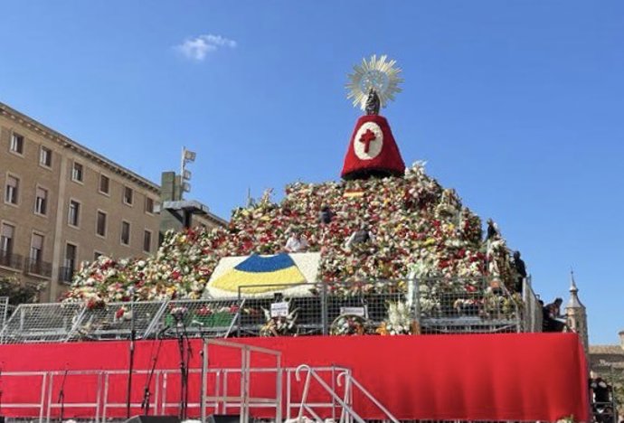 La bandera de Ucrania preside el manto de la virgen del Pilar con un centro de claveles amarillos y azules