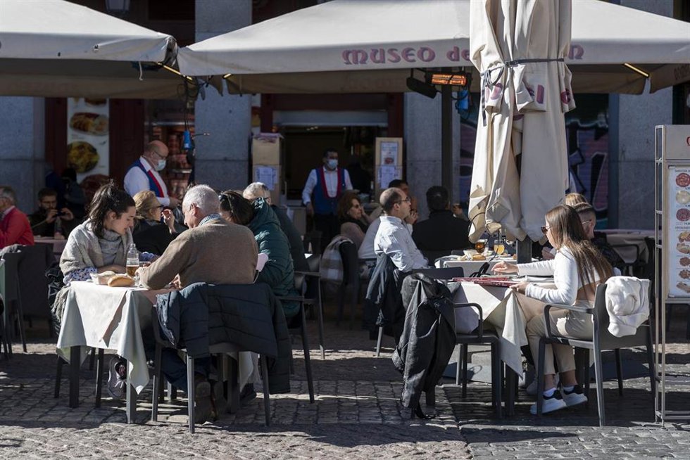 Archivo - Varias personas sentadas en una terraza.