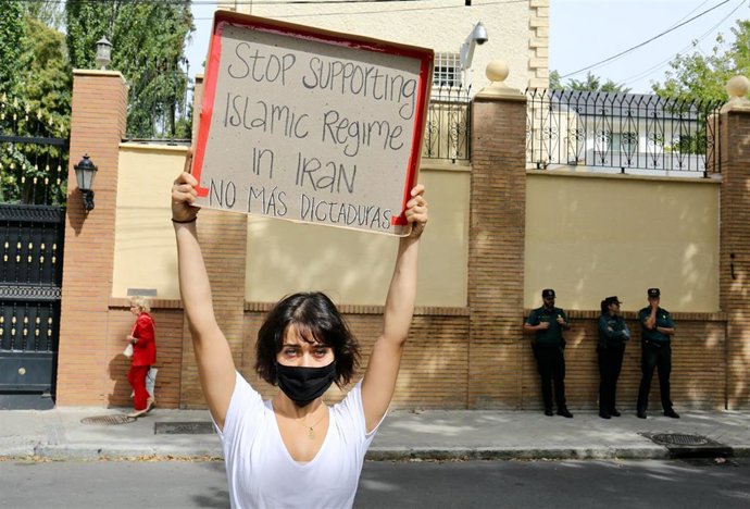 Una mujer con un cartel para protestar contra el régimen de Irán durante una concentración frente a la embajada de Irán