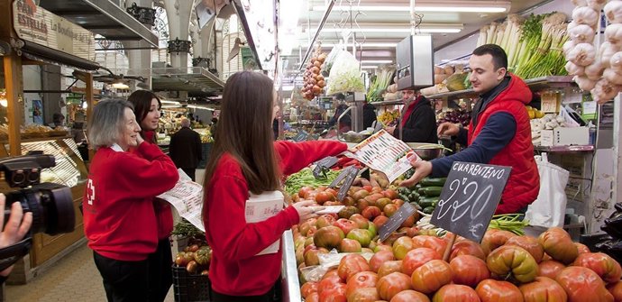 Voluntarios de Cruz Roja ofrecen información sobre alimentación saludable en un mercado.