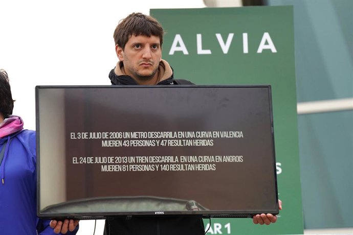 Un familiar de una víctima en el accidente de Alvia sujeta una pantalla de televisión con una imagen del exdirector de Seguridad en la circulación de Adif, Andrés Cortabitarte, mientras declara en el juicio por el accidente del Alvia, en la Cidade de la