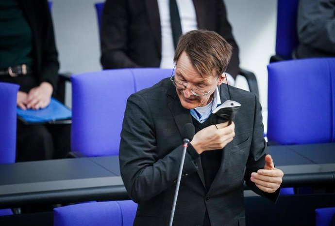 El ministro de Salud alemán, Karl Lauterbach, quitándose una mascarilla