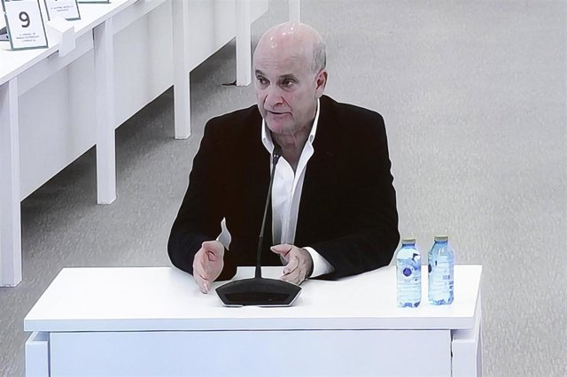 El exdirector de Seguridad en la circulación de Adif, Andrés Cortabitarte, visto desde la pantalla por la que los medios de comunicación observan el juicio por el accidente del Alvia, en la Cidade de la Cultura de Santiago de Compostela, a 6 de octubre de
