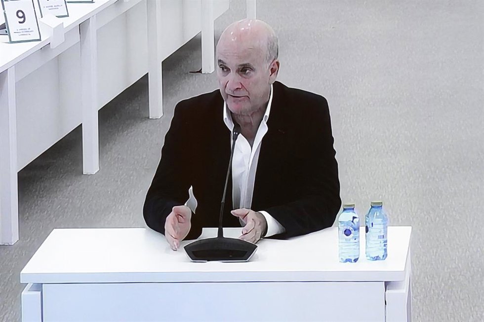 El exdirector de Seguridad en la circulación de Adif, Andrés Cortabitarte, visto desde la pantalla por la que los medios de comunicación observan el juicio por el accidente del Alvia, en la Cidade de la Cultura de Santiago de Compostela, a 6 de octubre 