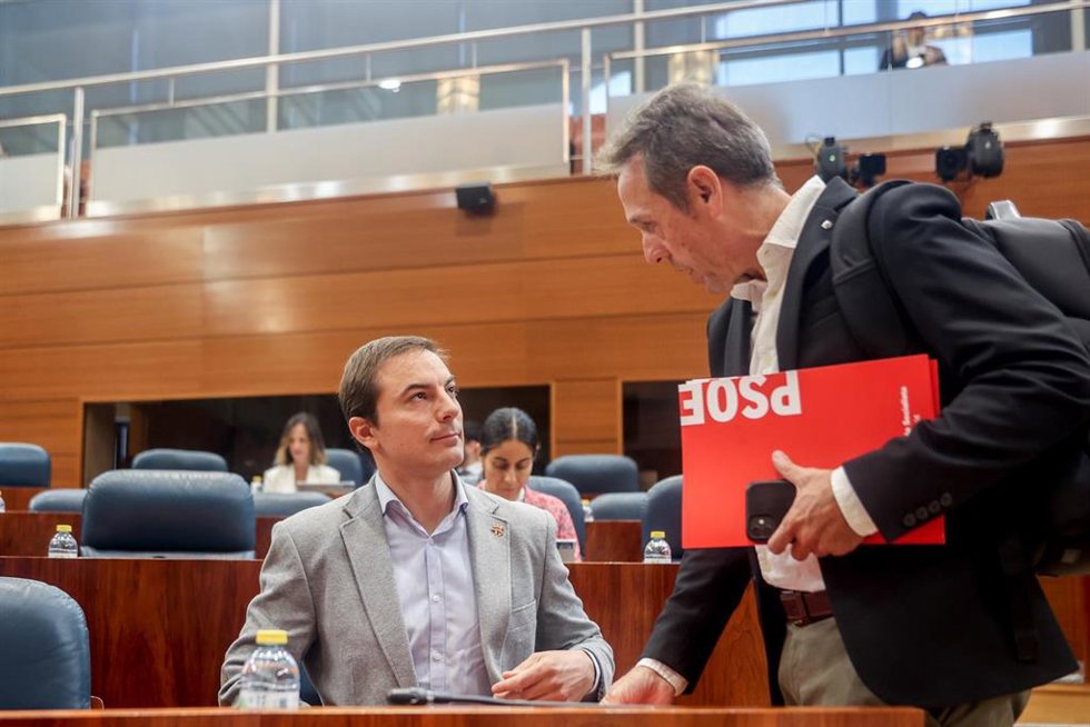 El candidato del partido socialista a la presidencia de la Comunidad de Madrid y secretario general del PSOE madrileño, Juan Lobato (i), habla con el diputado de su grupo, Fernando Fernández Lara, durante una sesión plenaria en la Asamblea de Madrid, a 