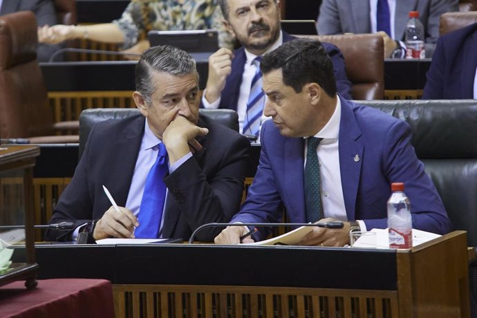 El consejero de Presidencia, Interior y Diálogo Social de la Junta de Andalucía, Antonio Sanz, (i) junto a el presidente de la Junta de Andalucía, Juanma Moreno, (d) durante la primera jornada del Pleno del Parlamento andaluz en el Parlamento de Andaluc