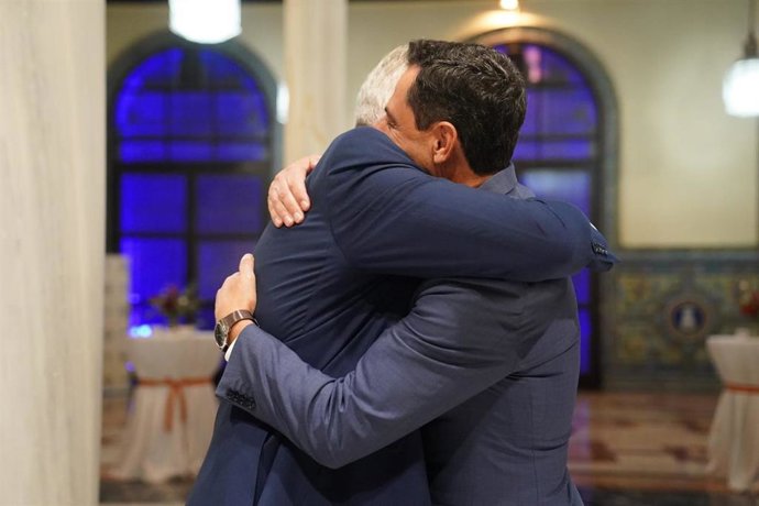 El presidente de la Junta de Andalucía, Juanma Moreno, (d) se abraza con el recién retirado teniente general de la Fuerza Terrestre José Rodríguez (i).