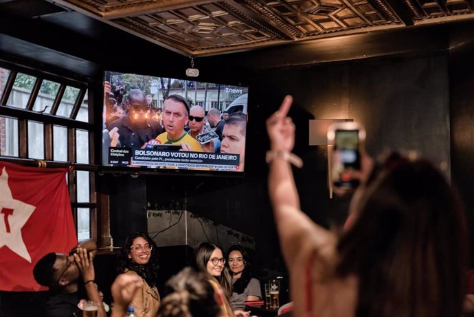 Seguidores del expresidente Luiz Inácio Lula da Silva siguen la primera vuelta de las elecciones de Brasil en un pub de Dublín, Irlanda.