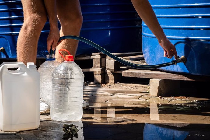 Archivo - August 16, 2022, Mykolaiv, Mykolaiv Oblast, Ukraine: A man fills up several bottles with water using a hose pipe at the water supply station, as the district has no water supply due to Russian shelling, in Mykolaiv. Mykolaiv, the strategic cit