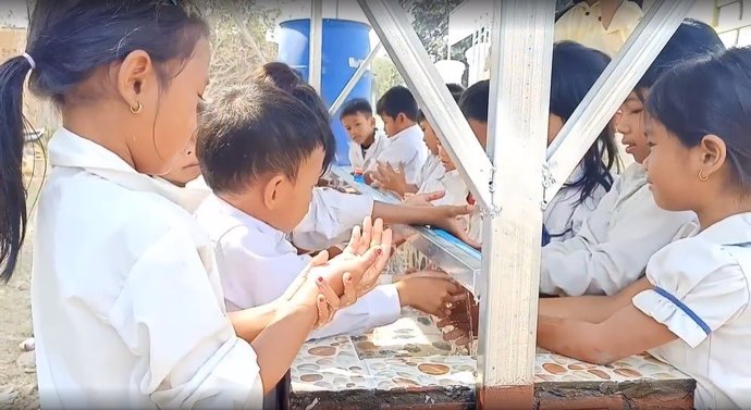 Alumnos de la escuela de Broylatngor, en Camboya, se lavan las manos en el lavabo comunitario construido gracias a la colaboración entre AUARA y la organización Karuna Battambang.