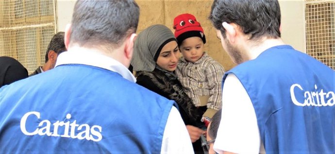 Archivo - Cáritas ayuda a una mujer refugiada con su hijo