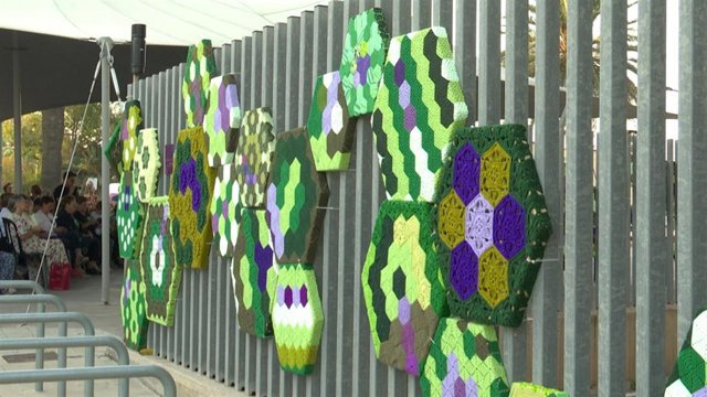 La organización Hilando Vidas ha creado una gran cadena de ADN formada por un total de 575 piezas tejidas en lana por 250 mujeres de la comarca valenciana de La Serranía que ha envuelto el exterior del Edificio Docks de València