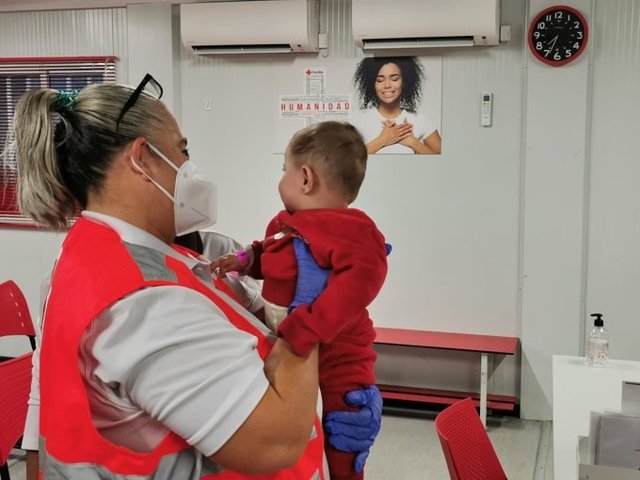 Una voluntaria de Cruz Roja con uno de los bebés rescatados de una patera este fin de semana en aguas de Almería