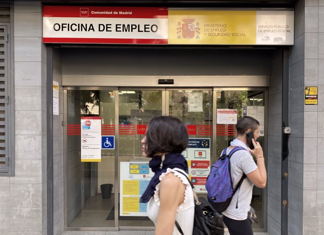 Dos personas pasan por la oficina de empleo de Acacias, a 4 de octubre de 2022, en Madrid (España). 

