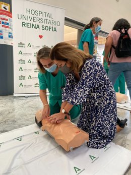 María Jesús Botella (dcha.) practica maniobras de reanimación cardiopulmonar con un maniquí en el Reina Sofía.