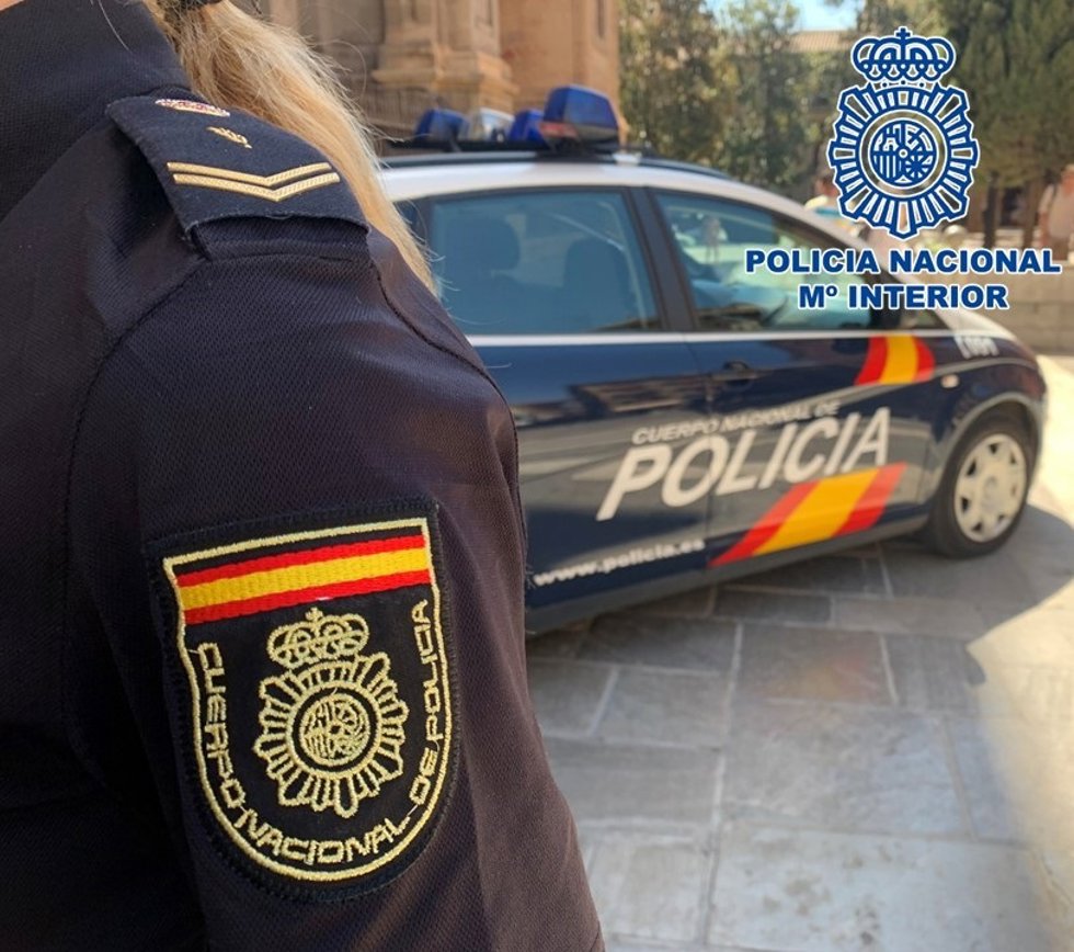 Archivo - Agente de la Policía Nacional, junto a su vehículo
