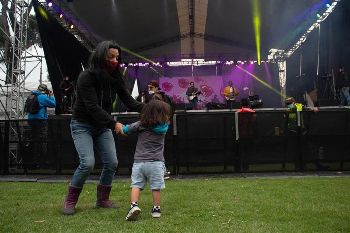 Una mujer y una niña bailando en un concierto en Bogotá