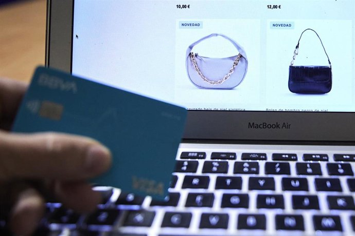 Archivo - Una persona compra con su tarjeta de crédito en un comercio electrónico