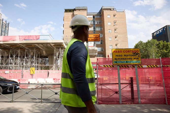 Archivo - Un albañil pasa por una obra, a 10 de agosto de 2022, en Madrid