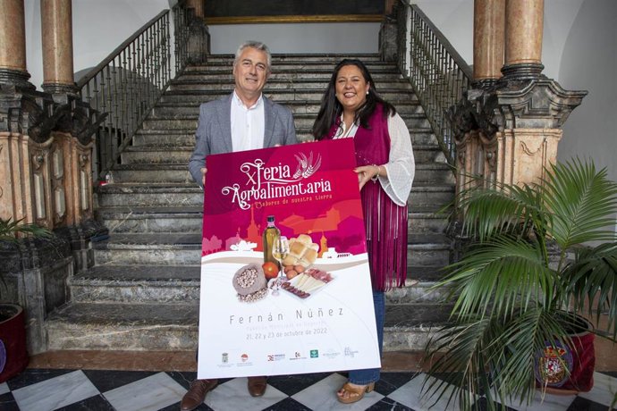 La presidenta de Iprodeco, Dolores Amo, y el alcalde de Fernán Núñez, Alfonso Alcaide, presentan el cartel de la Feria Agroalimentaria del municipio.