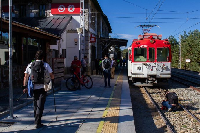 Archivo - Viajeros junto al tren en el andén de la estación de Cotos, a 3 de septiembre de 2022