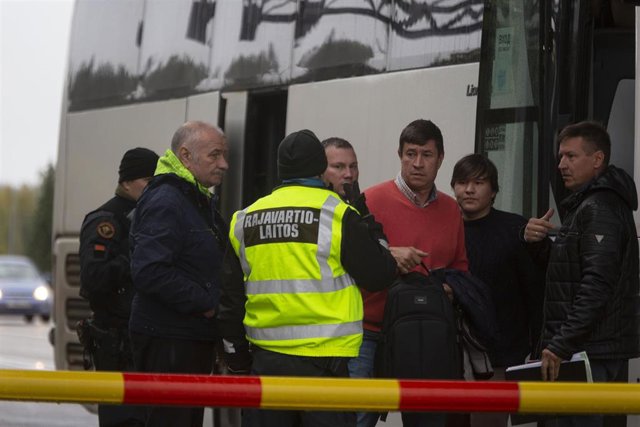 Guardias fronterizos finlandeses y ciudadanos rusos en un puesto de control.