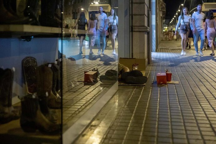 Archivo - Una persona duerme a las puertas de una zapatería durante la realización del censo de personas en situación de sinhogarismo llevado a cabo por la fundación Arrels, a 15 de junio de 2022, en Barcelona, Cataluña (España). Desde 2016, Arrels real