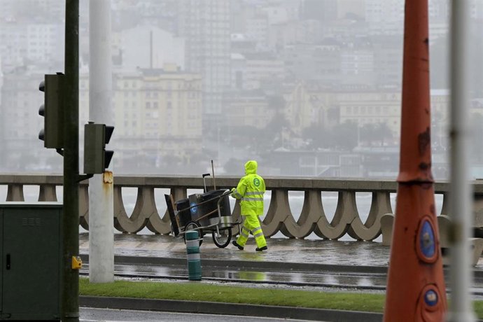 Archivo - Un barrendero camina por el Paseo Marítimo de La Coruña, se resguardan de la lluvia con paraguas, a 19 de junio de 2022, en A Coruña, Galicia, (España). La inestabilidad se mantendrá en Galicia al menos hasta la mitad de la semana que viene. A