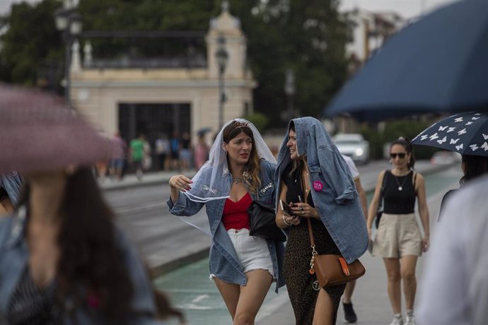 Archivo - Una mujer se cubre con un chaqueta vaquera por lluvias . A 13 de septiembre de 2022, en Sevilla (Andalucía, España).