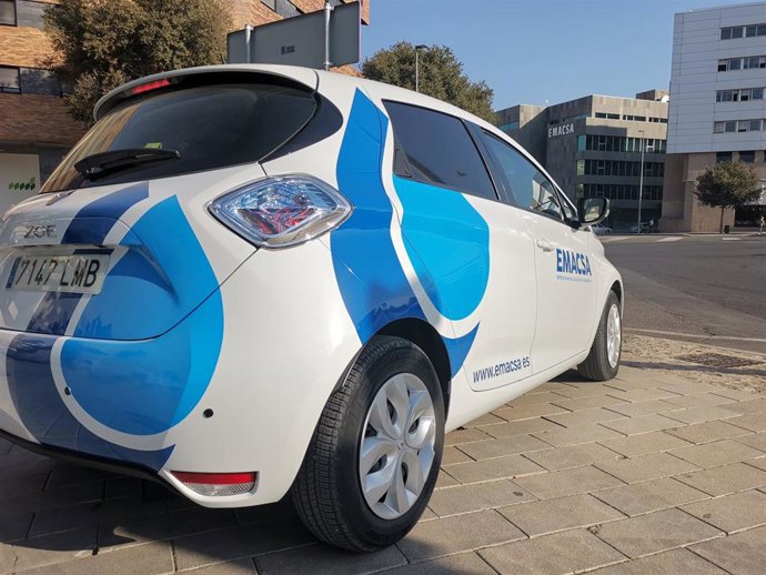 Un coche de Emacsa con la sede de la empresa municipal al fondo.