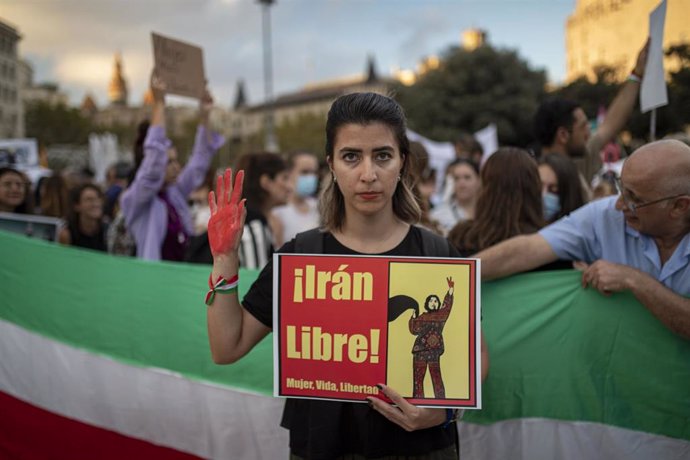 Una joven sujeta un cartel en el que pone 'Irán Libre' durante la manifestación en Barcelona contra el régimen Iraní tras la muerte de Mahsa Amini, a 15 de octubre de 2022, en Barcelona (España)