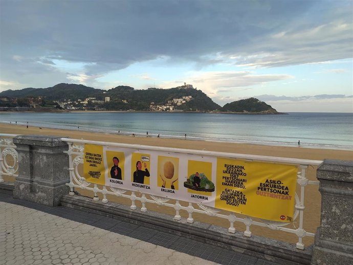 Pobreza Cero coloca carteles reclamando "políticas de asilo que protejan a todas las personas" en San Sebastián