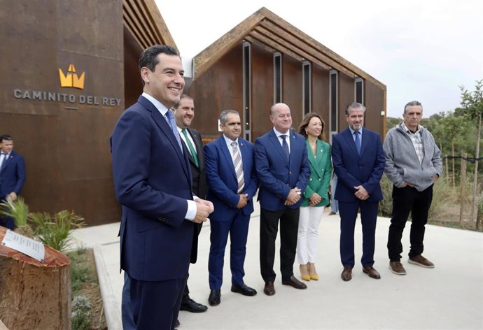 El presidente de la Junta de Andalucía, Juanma Moreno (i), durante la foto de familia en su visita al Centro de recepción de visitantes del Caminito del Rey, a 20 de octubre de 2022, en Málaga (Andalucía, España)