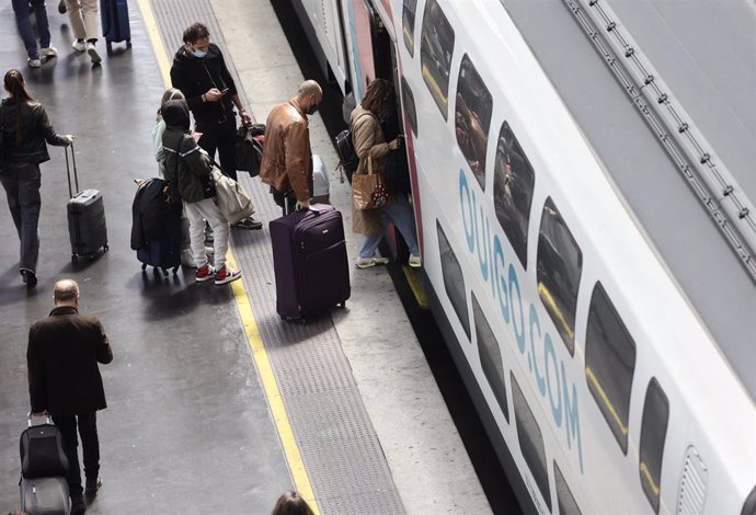 Archivo - Varias personas, con maletas, en el andén antes de coger un tren de alta velocidad