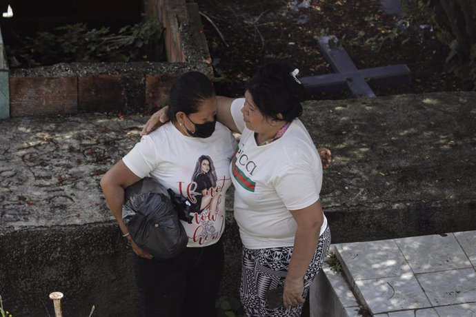 Los familiares de las víctimas de las inundaciones y del corrimiento de tierras lloran en el cementerio de la ciudad. 