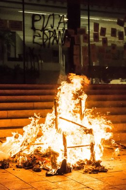 Miembros del CDR Girona colocan una foto de Pere Aragons en un contenedor junto a la bandera de España y con un cartel que dice: "Contenedor del diálogo" durante una manifestación con motivo del quinto aniversario del referéndum del 1-O, a 1 de octubre