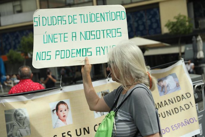 Archivo - Una  mujer, con una pancarta, durante una concentración de víctimas por el robo de bebés en España, en mayo de 2022.