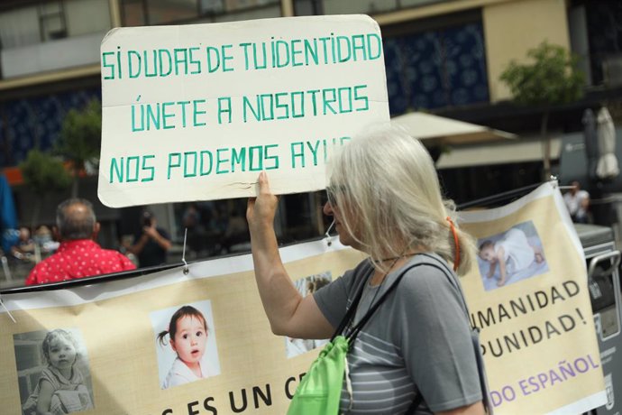 Archivo - Una  mujer, con una pancarta que reza 'Si dudas de tu identidad únete a nosotros, nos podemos ayudar' durante una concentración de víctimas por el robo de bebés en España, en la Plaza de Jacinto Benavente, a 22 de mayo de 2022, en Madrid (Espa