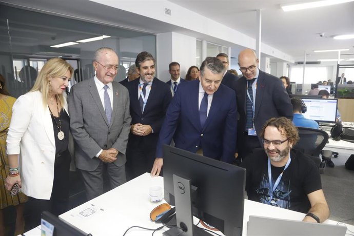 El consejero de Presidencia, Interior y Diálogo Social de la Junta de Andalucía, Antonio Sanz, (3d) , el alcalde y la consejera de Economía, Carolina España, dialoga con un trabajador en la inauguración de la sede de NTT Data en Málaga.