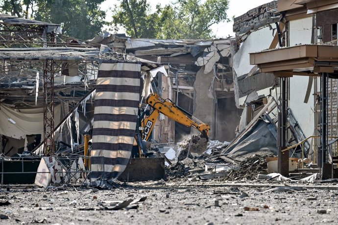 22 September 2022, Ukraine, Zaporizhzhia: An excavator clears debris in front of a building destroyed by Russian missile attacks. Photo: -/Ukrinform/dpa