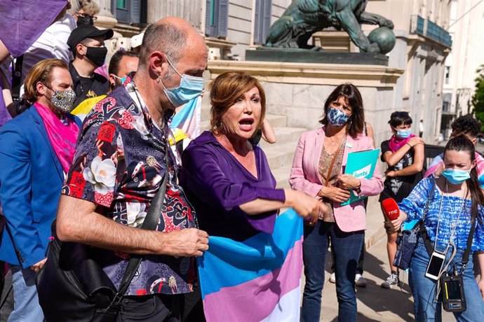 Archivo - Una activista por los derechos trans, Mar Cambrollé con una bandera trans en las escaleras del Congreso