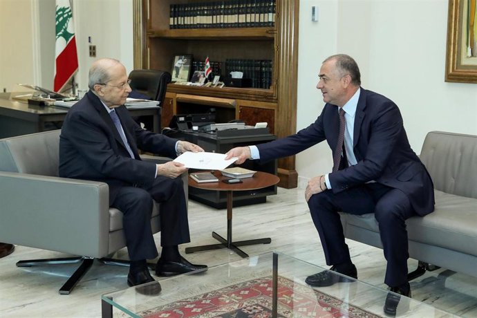 El negociador libanés Elias Bou Saab (D) entrega el pacto marítimo con Israel al presidente de Líbano, Michel Aoun 