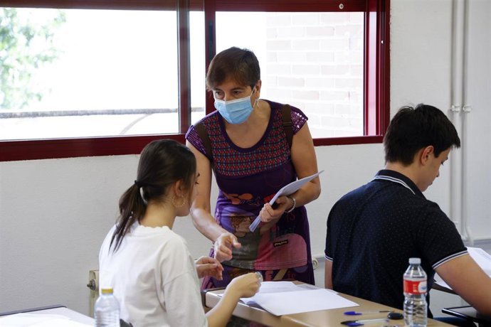 Archivo - Una profesora entrega exámenes a una alumna, a 8 de junio de 2022.