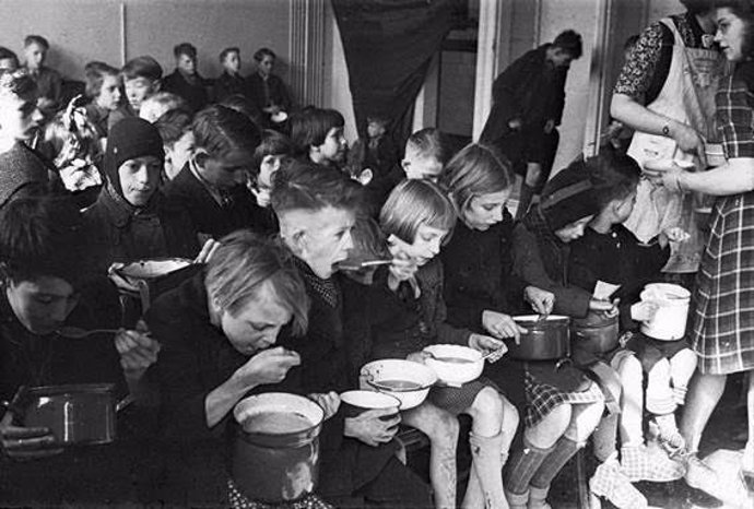 Niños holandeses comen sopa durante la hambruna de 1944-1945. /